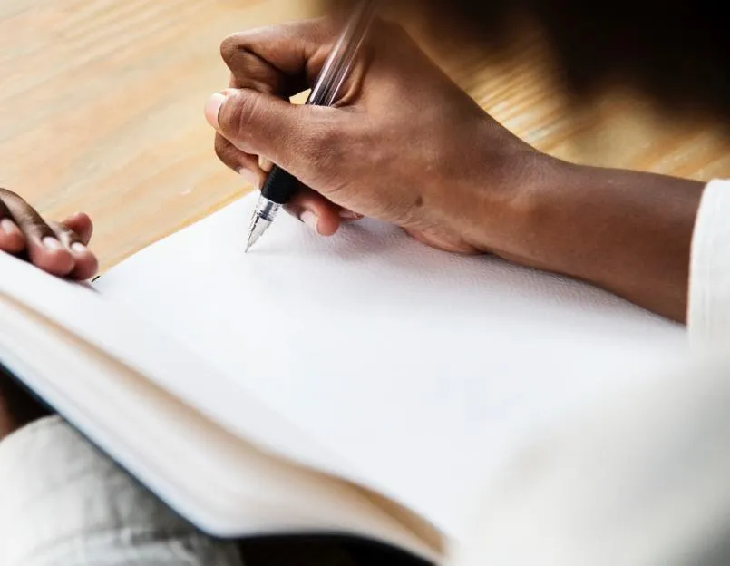 Groom writing personal wedding vows by hand